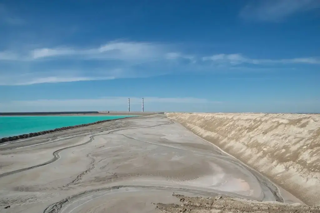 A stunning coastal landscape featuring turquoise waters and sandy shores under a clear blue sky.