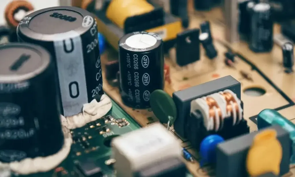 Detaillierte Nahaufnahme von Kondensatoren und Bauteilen auf einer Leiterplatte, die die Elektroniktechnik veranschaulicht.