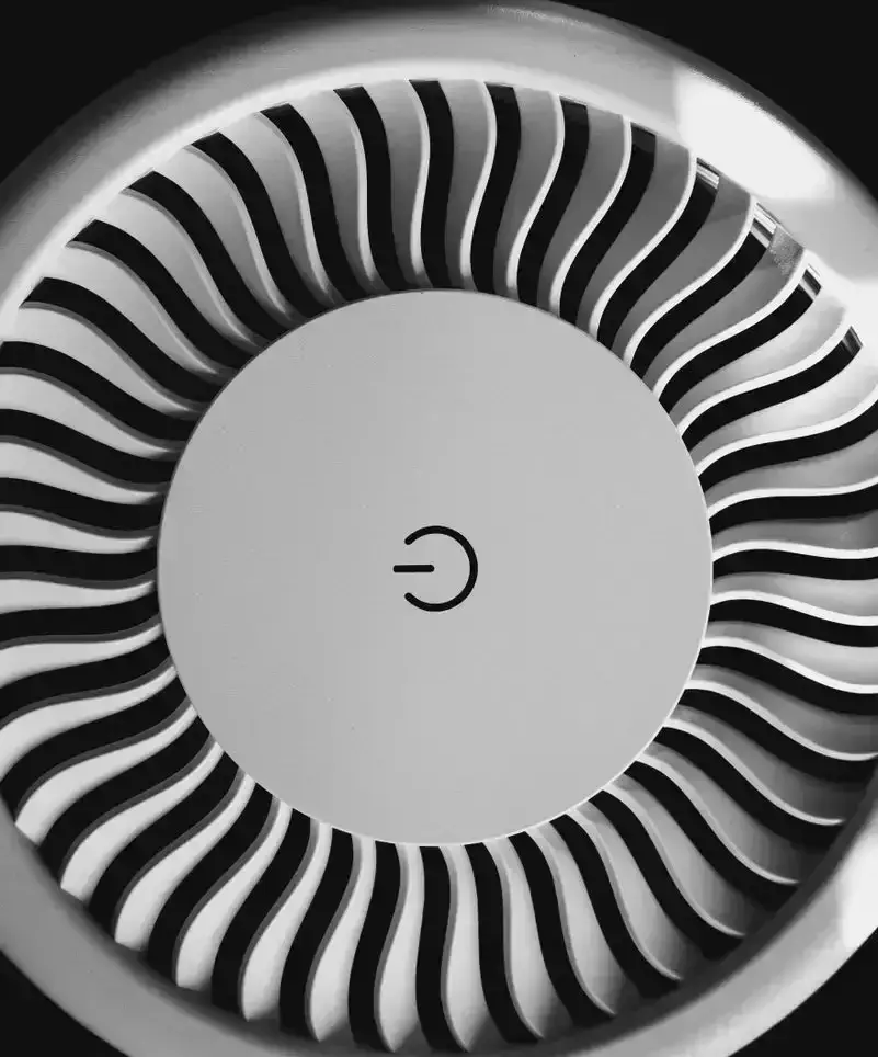 Black and white image of a circular fan with a prominent power symbol.