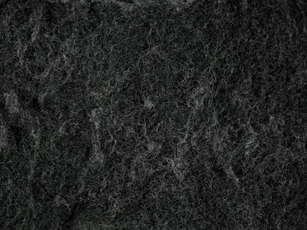 Detailed texture of a black dish sponge captured in macro photography, emphasizing fiber details.