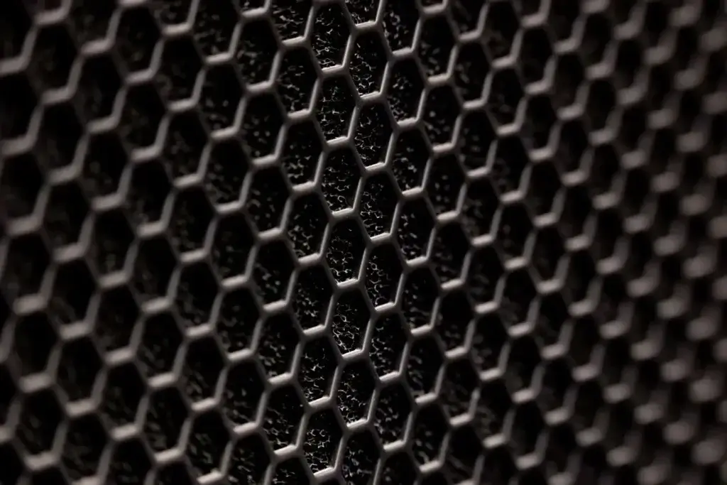 Detailed close-up of a dark hexagonal metal pattern with a textured surface.