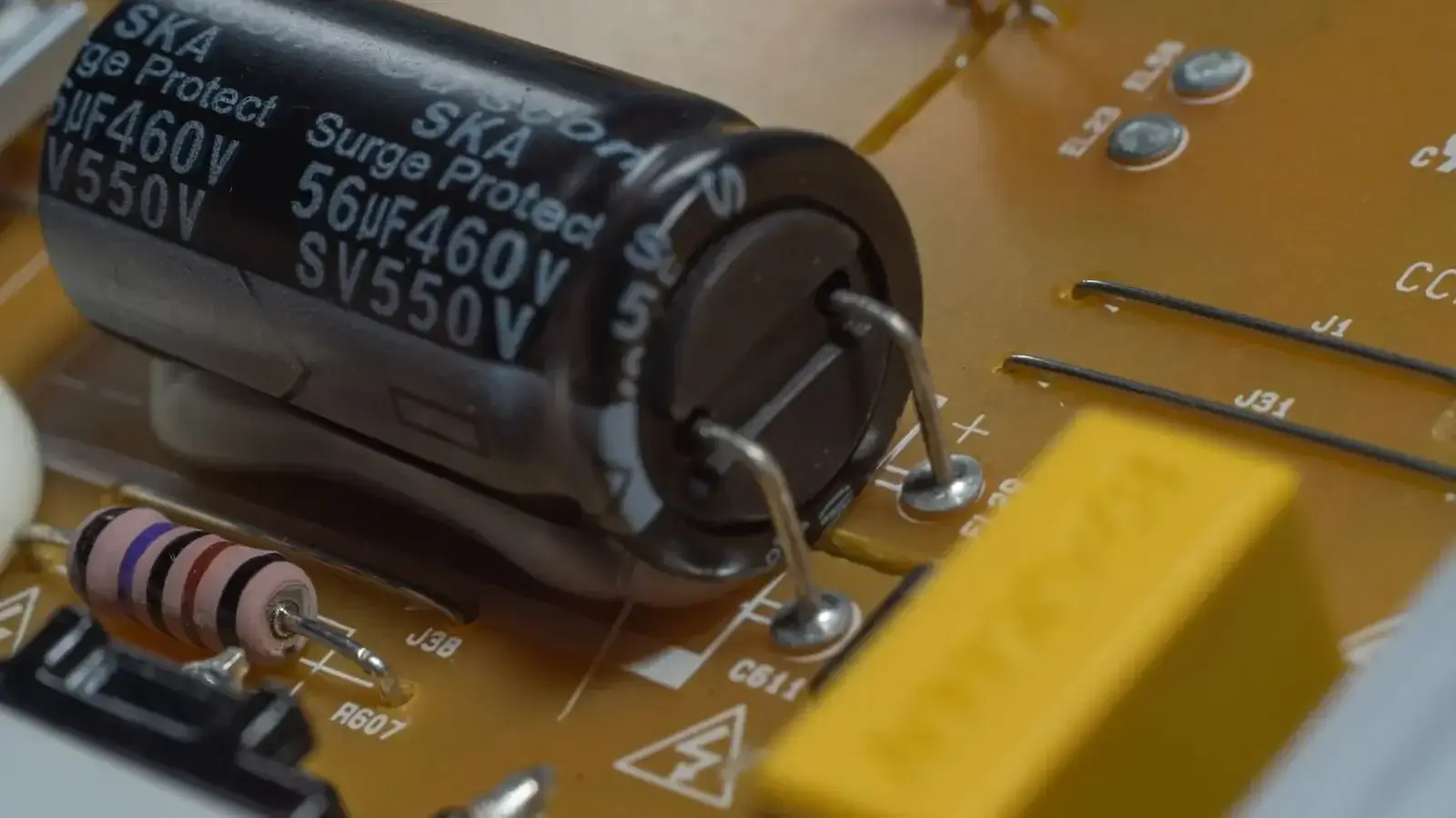 Detaillierte Nahaufnahme von elektronischen Bauteilen auf einer Leiterplatte, darunter ein Kondensator und ein Widerstand.